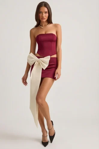 Carola Satin Bow-Detail Low-Rise Mini Skirt in Wine Red