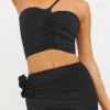 Tesia Slinky Jersey Rose Detail Asymmetric Top in Black
